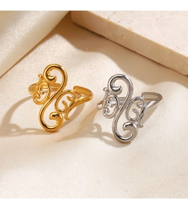 Detailed view of gold and silver filigree rings on beige silk with stone accents