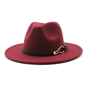 Close-up of wine red fedora hat with black band and gold metal buckle detail