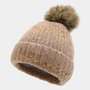 Detailed view of camel knit beanie with a dark brown faux fur pom pom and textured weave