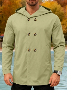 Detail of olive green hooded trench coat with double-breasted buttons in autumn woods