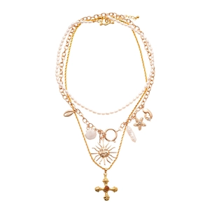 Layered gold necklace with freshwater pearls, sun face charms and cross pendant