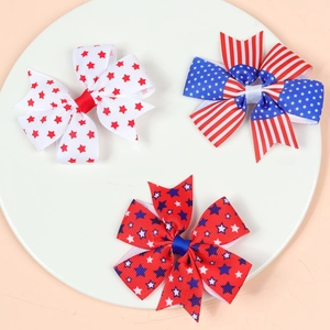 Close-up of three US Independence Day themed hair bows on a white tray with stripe patterns