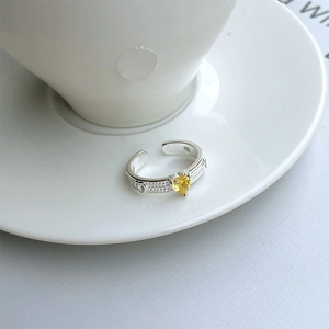 Detail of 925 silver ring featuring a yellow heart zircon and embossed woven band