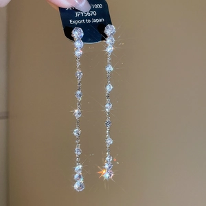Macro view of long silver teardrop tassel earrings with sparkling zircon stones