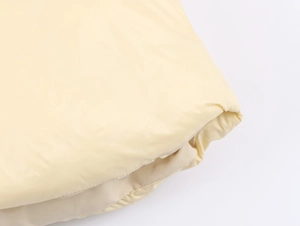 Detailed macro view of high-gloss yellow puffer jacket fabric with puffy quilted texture