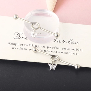 Macro view of silver industrial barbell with sparkling rhinestone butterfly charms