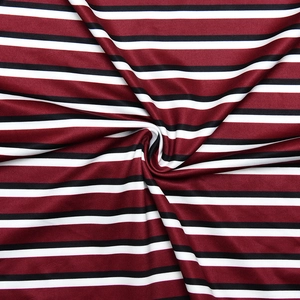 Close-up of soft knitted striped fabric in burgundy, black and white with visible texture