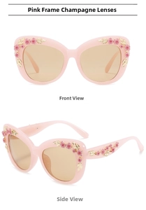 Pink cat-eye sunglasses featuring floral ornaments and champagne lenses in detail view