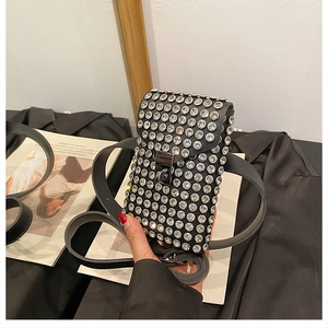 Detail of a black rhinestone crossbody bag with silver crystal accents and metal lock
