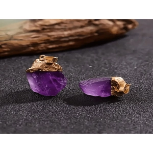 Unregelmäßige natürliche Amethyst-Anhänger mit vergoldetem Rand auf dunklem Grund