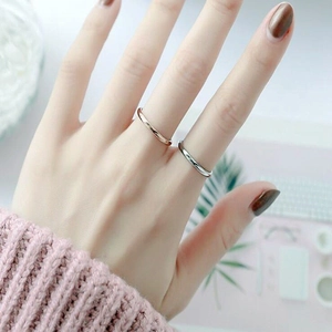 Close-up of minimalist rose gold and silver thin titanium steel rings worn on hand