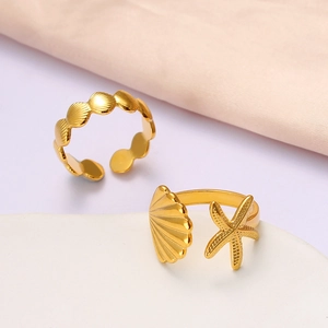 Macro detail of golden starfish and seashell open rings with marine holiday style textures