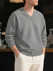 Detailed close-up of grey V-neck knit sweater with vertical cable textured pattern