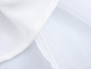 Dettaglio delle cuciture precise e della trama del tessuto in chiffon bianco lucido
