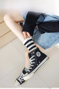 Close-up of striped cotton crew socks with knitted texture worn with canvas shoes