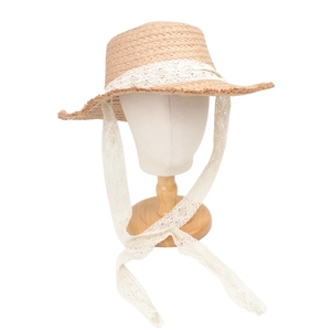 Detail of flat top straw sun hat with wide brim and white floral lace ribbons