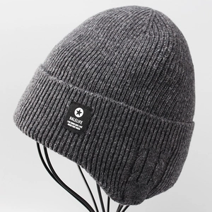 Close-up of dark grey knitted beanie with textured ribbing and black brand label