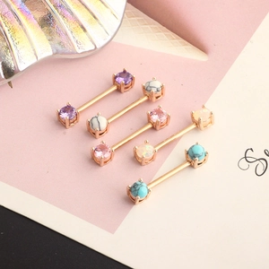 Rose gold stainless steel nipple rings set with colorful zircon stones on soft pink background