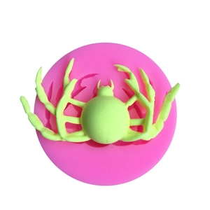 Dettaglio di uno stampo in silicone rosa e creazioni a forma di ragno verde chiaro