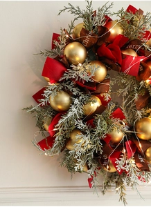 Close-up of luxury 40cm Christmas wreath with red berries, gold ornaments and LED lights