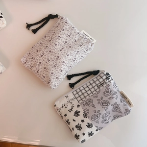 Detail of floral cotton pouches with zipper pull and simple wish fabric label