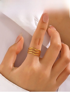 Detail of three-layer gold-plated wave ring with unique hammered texture on model hand