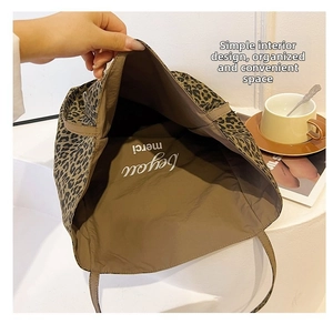 Interior view of leopard print tote bag showing spacious design and artistic lettering