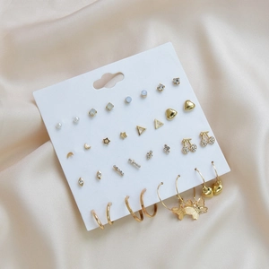 Detail view of 15 pairs of gold geometric stud and hoop earrings on white card display