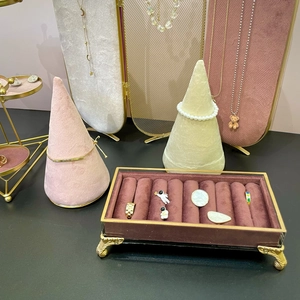 Pink and beige velvet jewelry display set with golden metal stands and storage tray