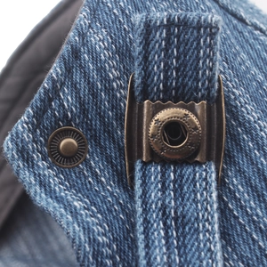 Close-up of vintage denim beret with bronze star buckle and adjustable metal strap