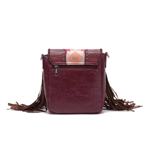 Detail of bohemian burgundy crossbody bag featuring floral embossing and stylish side fringes