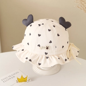 Close-up of baby bucket hat with heart print, 3D heart details, and ruffled brim