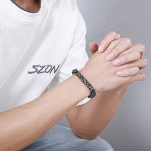 Détail d'un bracelet à maillons mécaniques gris foncé en acier titane style industriel