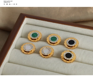 Detailed macro of vintage gold-plated titanium earrings with malachite and shell inlay