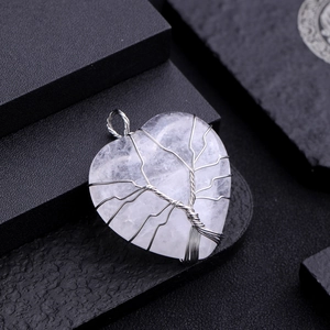 Macro shot of silver wire tree of life wrapped on a white crystal heart pendant