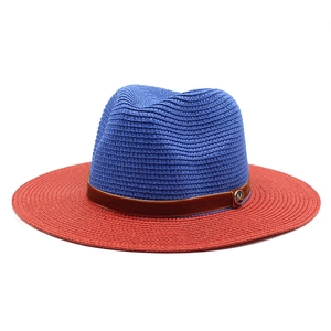 Close-up of blue and red straw panama hat with gold M badge and brown suede band