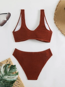 Detailed flat lay of brick red high waisted bikini with textured seersucker fabric and accessories
