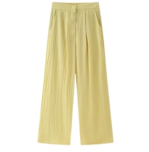 Détail du tissu du pantalon large taille haute jaune clair avec ceinture élastique