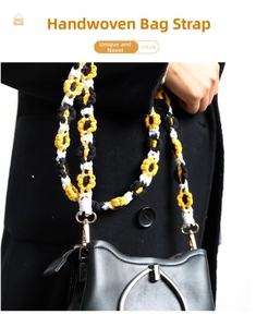 Detail of handmade daisy woven strap with yellow, black, white ropes and gold hooks