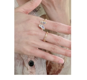 Detail of vintage style butterfly and gold chain rings with purple crystals and pavé stones