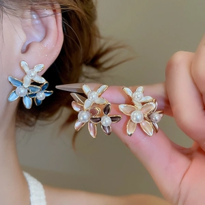 Close-up of 18K gold-plated flower stud earrings with gradient petals and pearl center