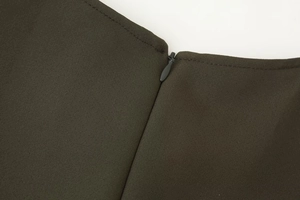 Macro shot of the concealed zipper detail on a dark olive green midi dress