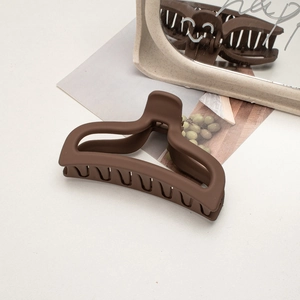 Detail showing the matte dark brown finish and frosted texture of the large hair claw clip