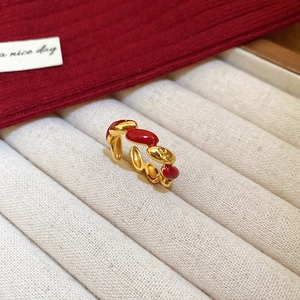 Macro detail of red enamel and gold plated segment ring on velvet display tray