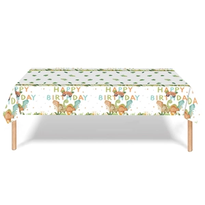 Cartoon dinosaur themed birthday party tablecloth with green leaf motifs and happy birthday text