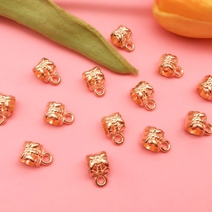 Macro shot of KC gold bee charms for DIY jewelry making with floral backgrounds