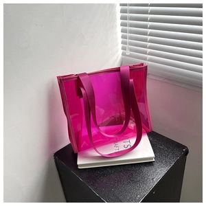 Detail of transparent rose pink PVC tote bag on art books with minimalist lighting