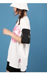 Detail view of the black sports arm bag featuring double heart zippers on a model's arm