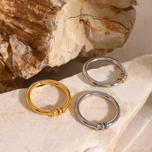 Minimalist 18k gold and silver stainless steel rings featuring movable round beads on rock