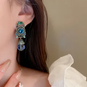 Vintage French gold earrings with blue crystal and colorful rhinestones on a model